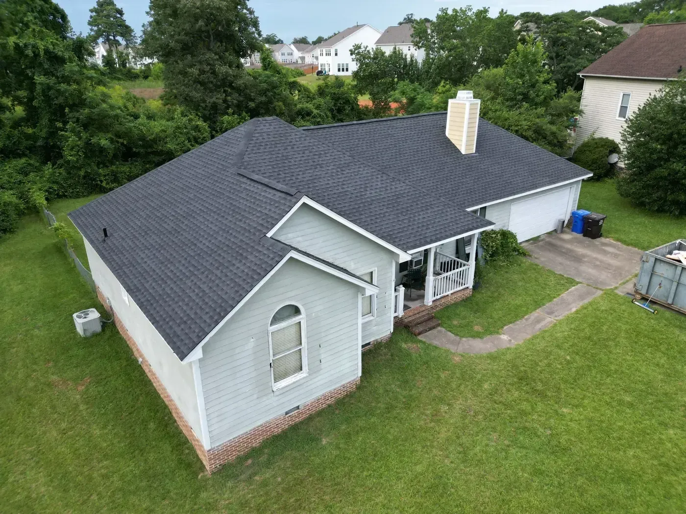 Close-up of new GAF Timberline HDZ Charcoal shingles on a finished roof repair section of an Angier, NC home