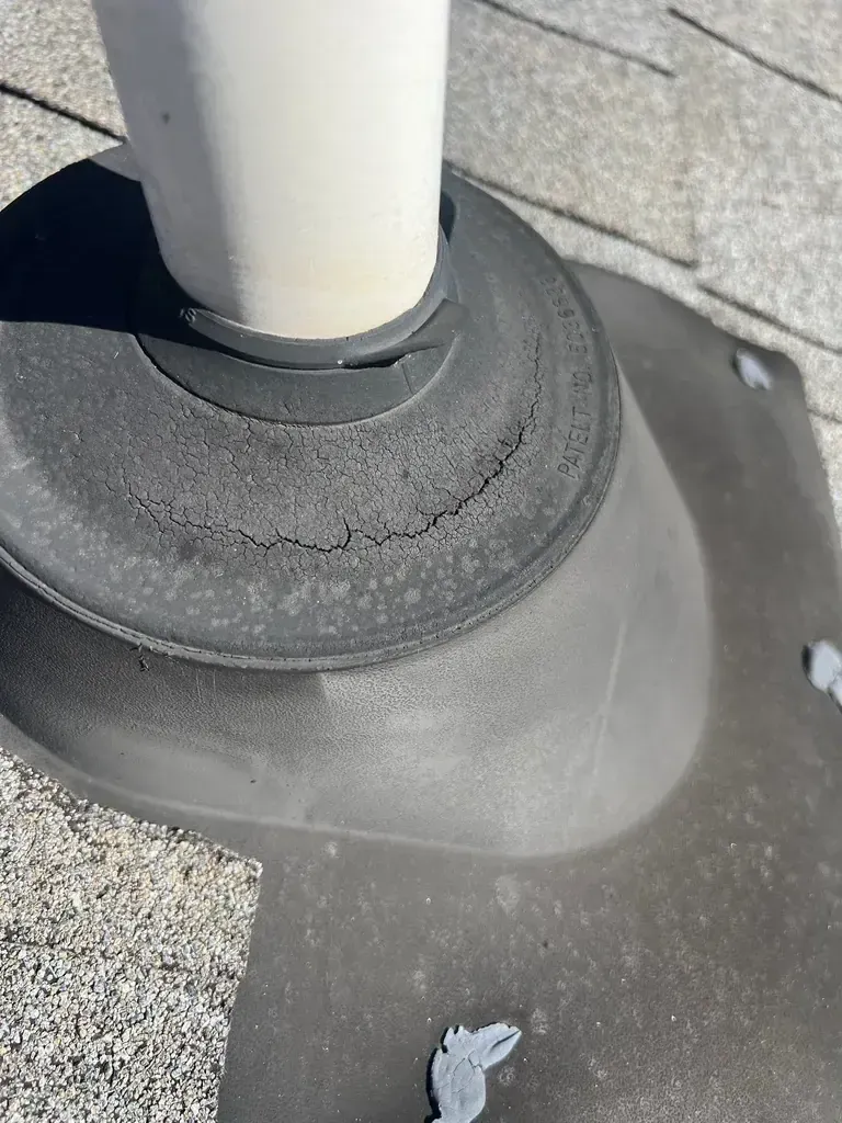Cracked rubber pipe boot around plumbing vent showing deterioration and separation
